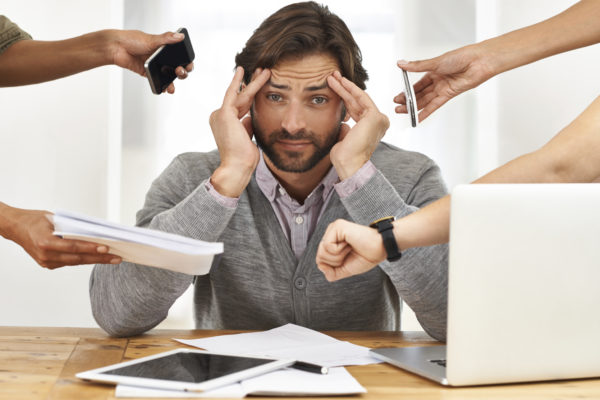 A cropped shot of a handsome businessman under strain as colleagues request various things from him